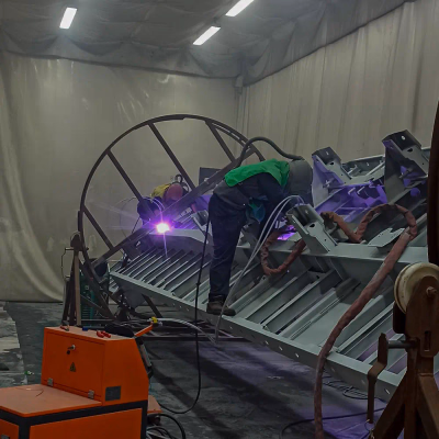 Ağır sanayi parçaları için özel olarak tasarlanmış döner platform üzerinde robotik metal kaplama işlemi.